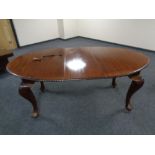 A mahogany oval extending dining table with leaf together with a set of five chairs