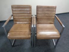 A pair of metal framed stitched brown leather armchairs