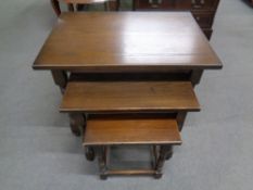 A nest of three tables in an oak finish