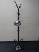 A contemporary metal hat and coat stand on four way pedestal together with a floor lamp in a chrome