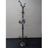 A contemporary metal hat and coat stand on four way pedestal together with a floor lamp in a chrome