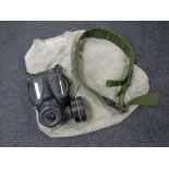 A military issue gas mask together with a belt and canvas bag