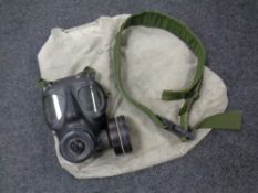 A military issue gas mask together with a belt and canvas bag