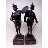A pair of painted spelter figures on black marble bases