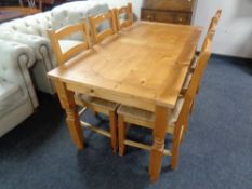 A contemporary pine dining table and set of six rush seated chairs