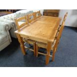 A contemporary pine dining table and set of six rush seated chairs