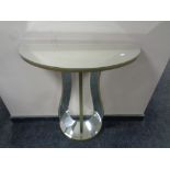 A contemporary mirrored D-shaped side table