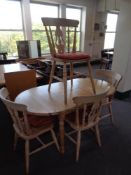 An oval pine extending kitchen table together with a set of four pine chairs