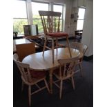 An oval pine extending kitchen table together with a set of four pine chairs