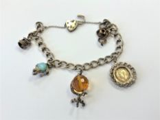 A silver charm bracelet set with various charms CONDITION REPORT: 30g