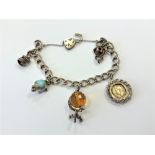 A silver charm bracelet set with various charms CONDITION REPORT: 30g