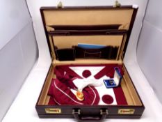 A leather briefcase containing Masonic regalia including sash,