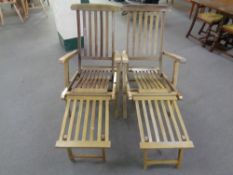 A pair of teak steamer garden armchairs with footrests,