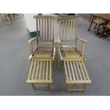 A pair of teak steamer garden armchairs with footrests,