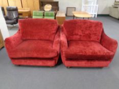 A pair of cuddle armchairs upholstered in a red fabric