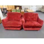 A pair of cuddle armchairs upholstered in a red fabric