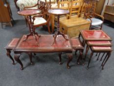 A carved beech nest of tables with tooled red leather insert together with a similar nest of tables
