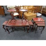 A carved beech nest of tables with tooled red leather insert together with a similar nest of tables