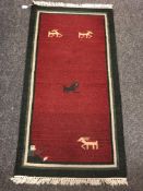 An eastern flatweave rug on red ground 73 cm x 140 cm