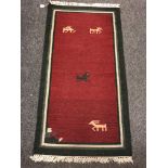 An eastern flatweave rug on red ground 73 cm x 140 cm