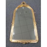A gilt framed bevelled hall mirror decorated with roses.