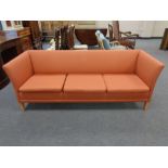 A twentieth century Danish three seater settee upholstered in a burnt orange fabric