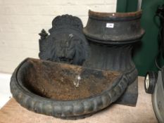 A large cast iron garden wall mounted water feature with cast iron head and flower decoration