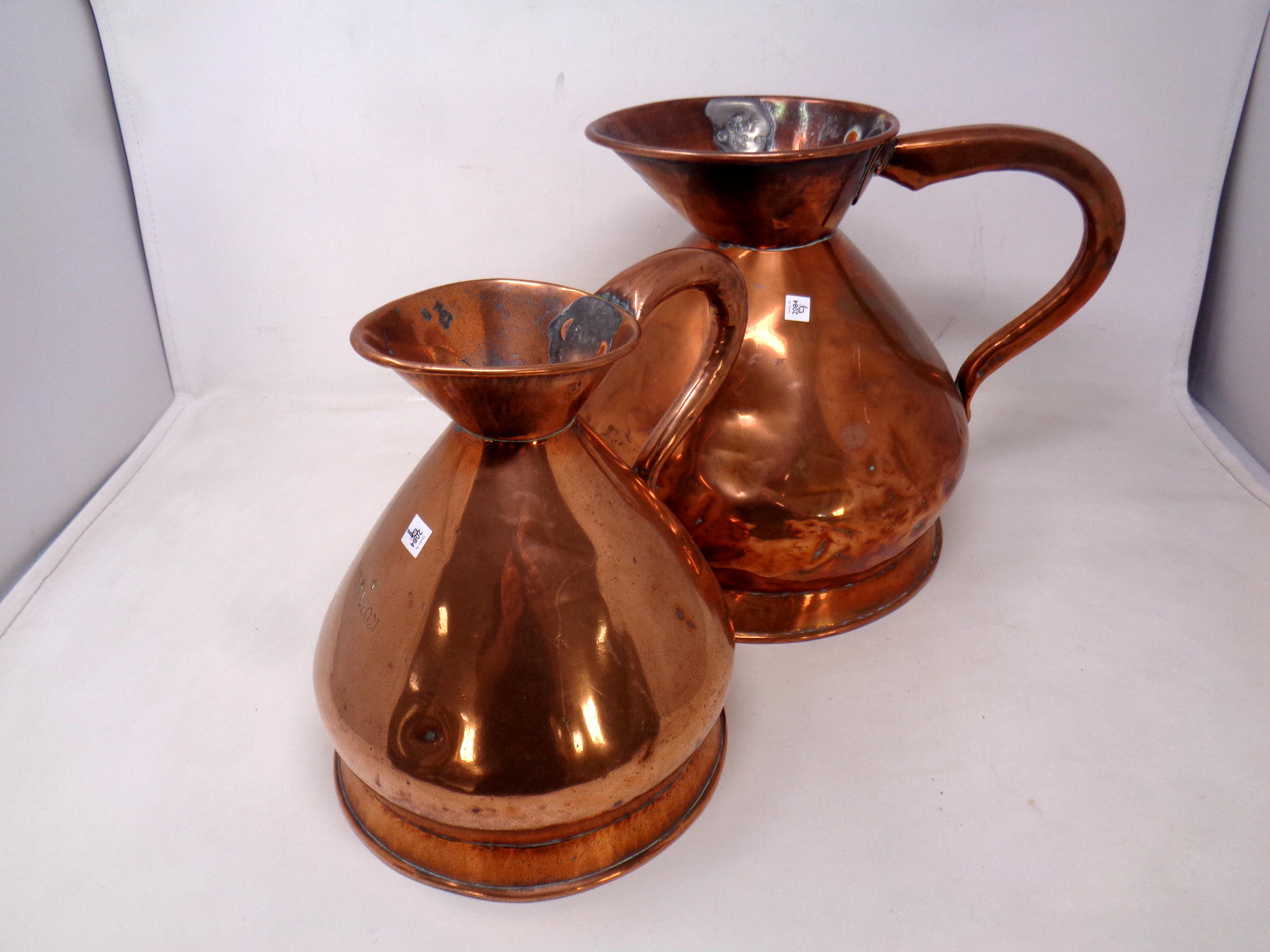 Two Victorian copper gallon and half gallon measuring jugs
