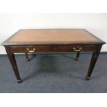 An Edwardian two drawer library table with leather inset panel