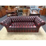 A good Chesterfield oxblood buttoned leather three seater scroll arm settee