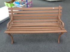 A wooden slatted garden bench with cast iron ends