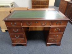 A mahogany twin pedestal writing desk, fitted nine drawers,