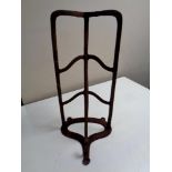 An antique cast iron wall mounted saddle rack