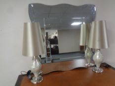 A shaped all glass mirror and a pair of contemporary table lamps