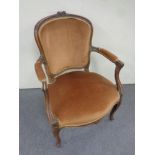 A carved beech French style salon armchair in gold fabric