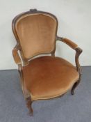 A carved beech French style salon armchair in gold fabric