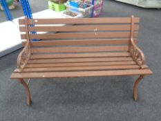 A wooden slatted garden bench with cast iron ends