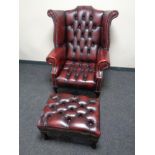 A good Chesterfield oxblood buttoned leather wingback armchair with matching footstool