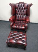 A good Chesterfield oxblood buttoned leather wingback armchair with matching footstool