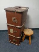 A small rustic tripod stool and a vintage shipping trunk
