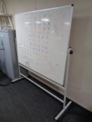 A double sided white board on stand