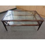A rectangular glass topped coffee table on wooden base