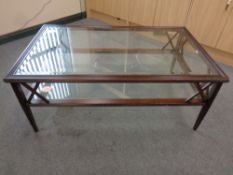 A rectangular glass topped coffee table on wooden base