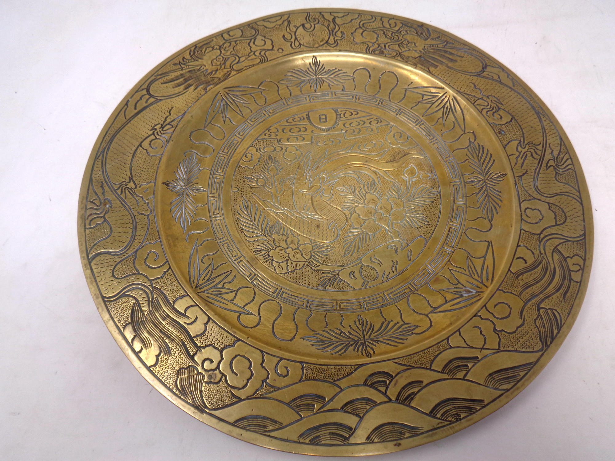 A heavy brass Chinese plate, diameter 30 cm.