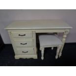 A contemporary cream single pedestal dressing table with similar footstool