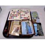 A tray of sew on patches, postcards, stamp album,