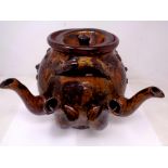 A very large folk art slipware four spouted stone ware teapot with applied decoration of lions and