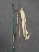 An archery bow and walking stick bearing badges and two 2-piece fishing rod including a Shakespeare