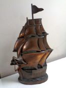 A copper and cast iron hearth companion set in the form of a galleon, complete with brush and tongs.