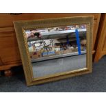 A gilt framed mirror bearing Rolex advertising